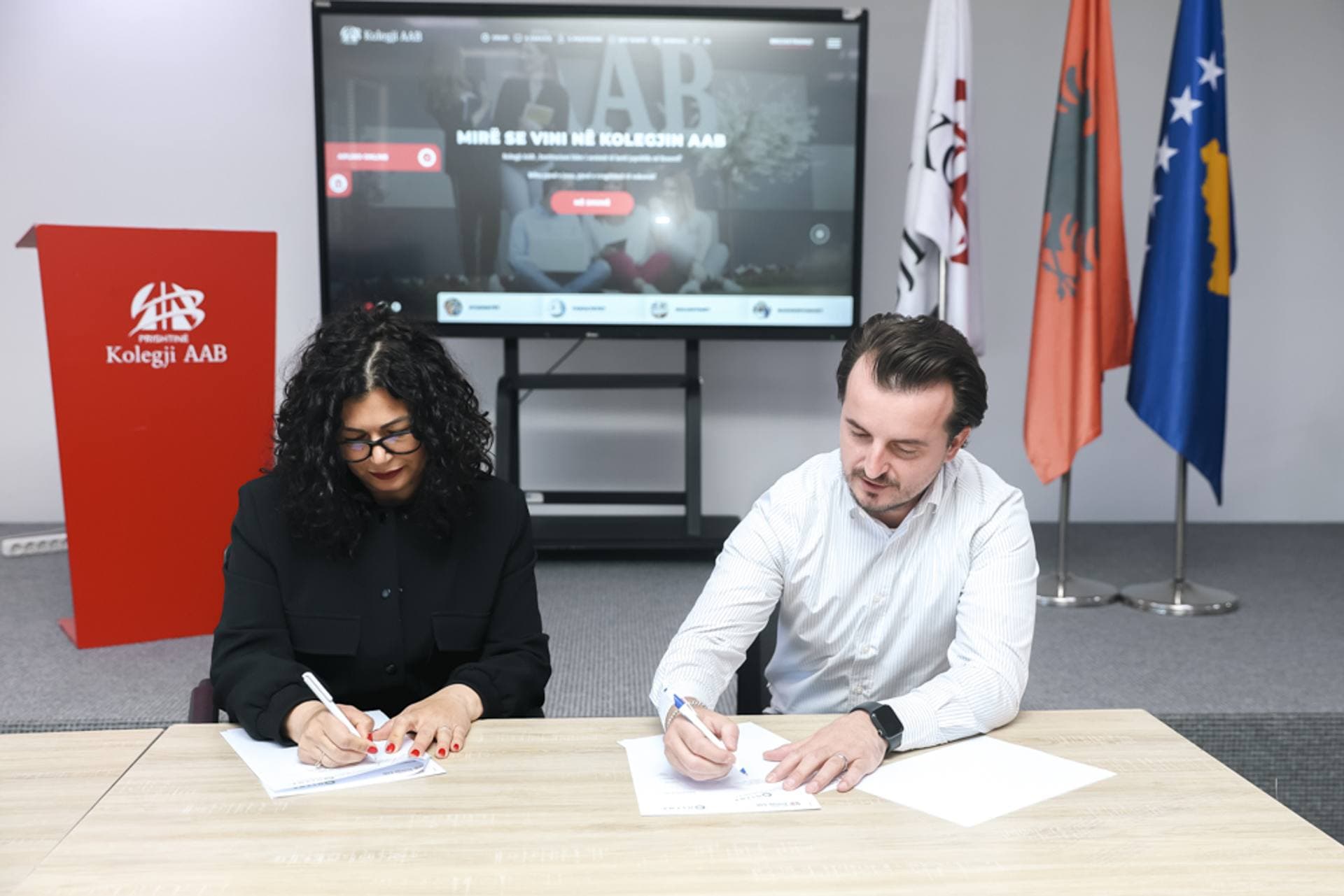 Dean Aida Alla and Director Jeton Aliu signing the cooperation agreement between AAB College and OLYMP BPO
